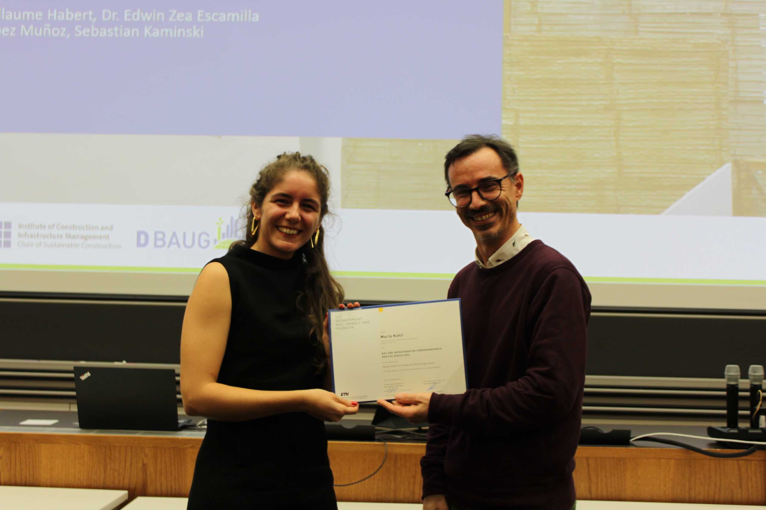 Prof. Guillaume Habert (IBI Lehrstuhl für Nachhaltiges Bauen) überreicht den diesjährigen BI-​Förderungspreis 2024 an Marla Köhli.